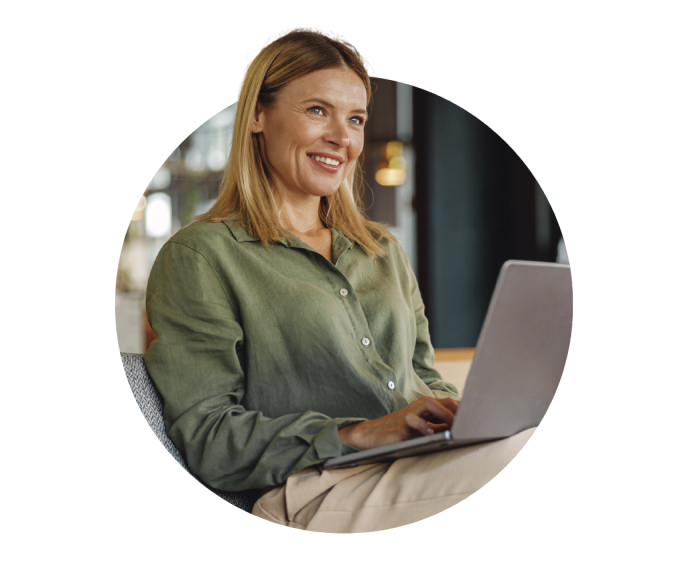 A woman with a smile working on a laptop