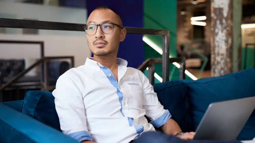 A gentleman in a white shirt working on a laptop